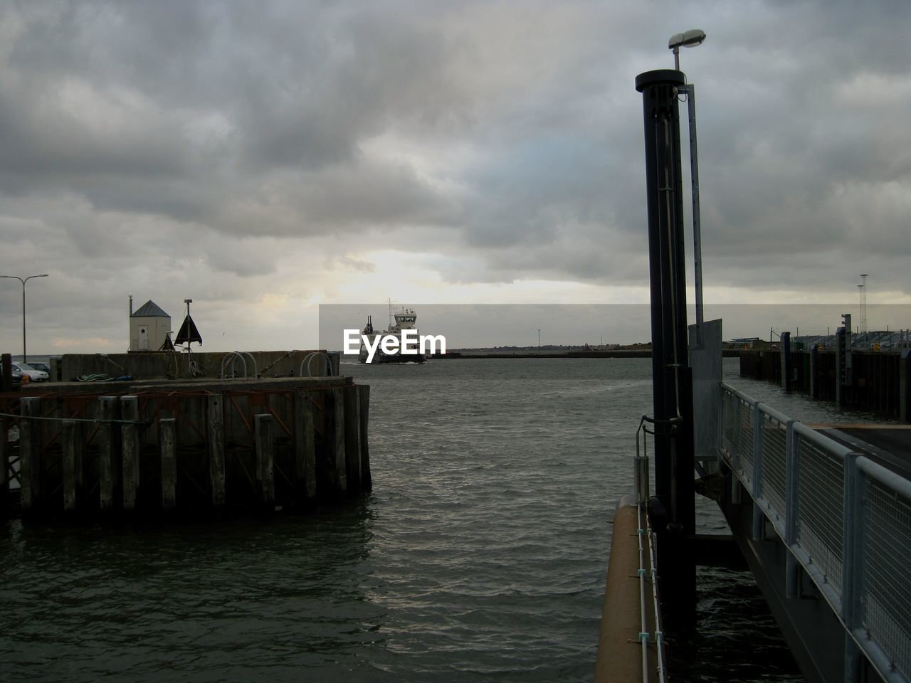 PIER OVER SEA AGAINST CLOUDY SKY