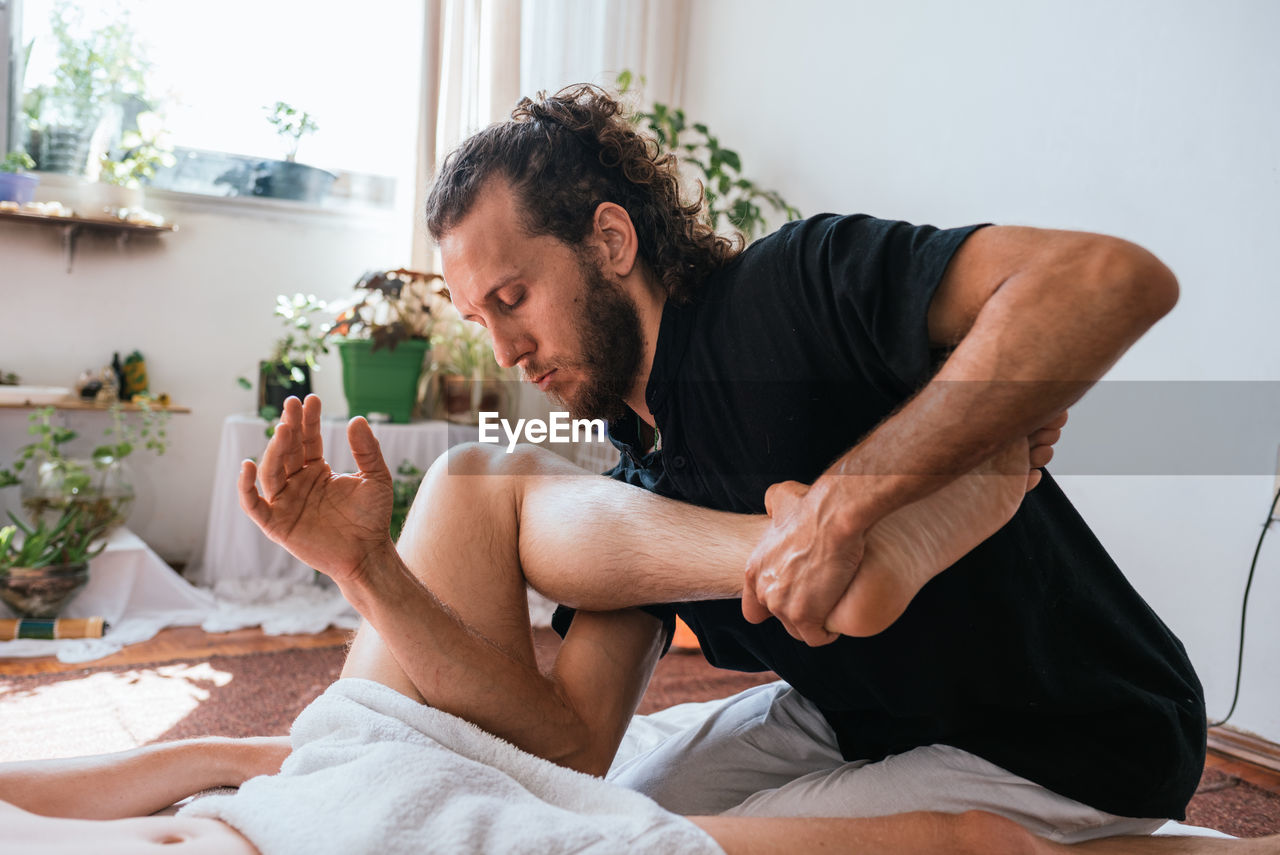 Midsection of man sitting on table at home