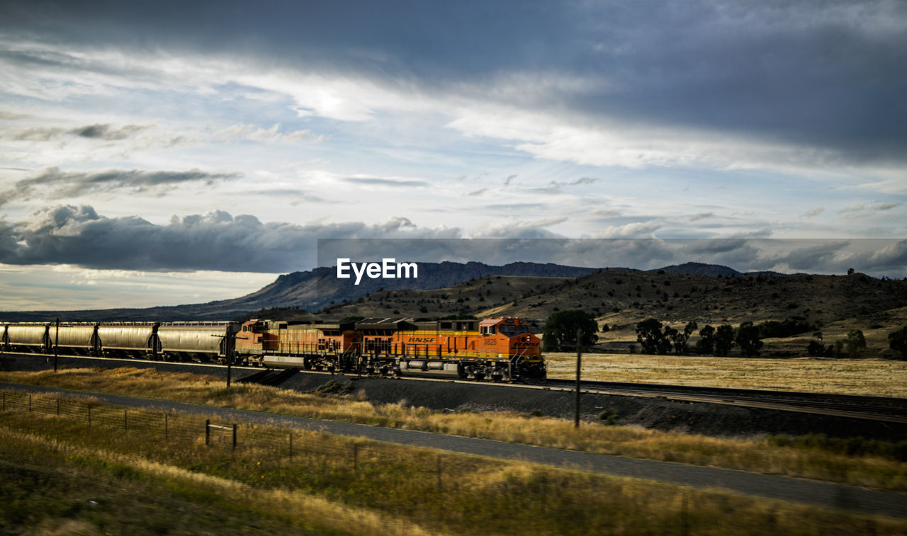 VIEW OF RAILROAD TRACK AGAINST CLOUDY SKY