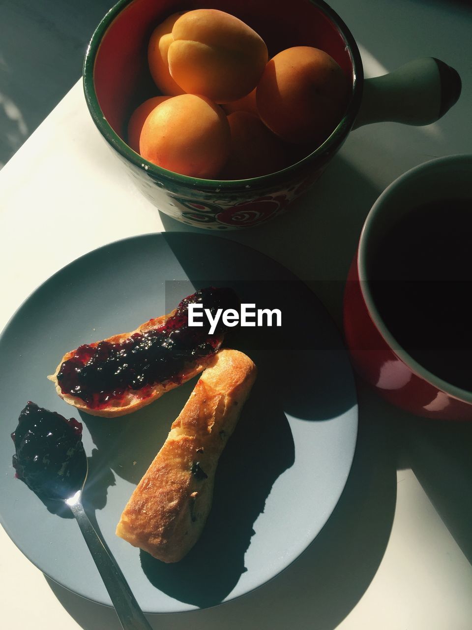 High angle view of apricot and bread with jam on table