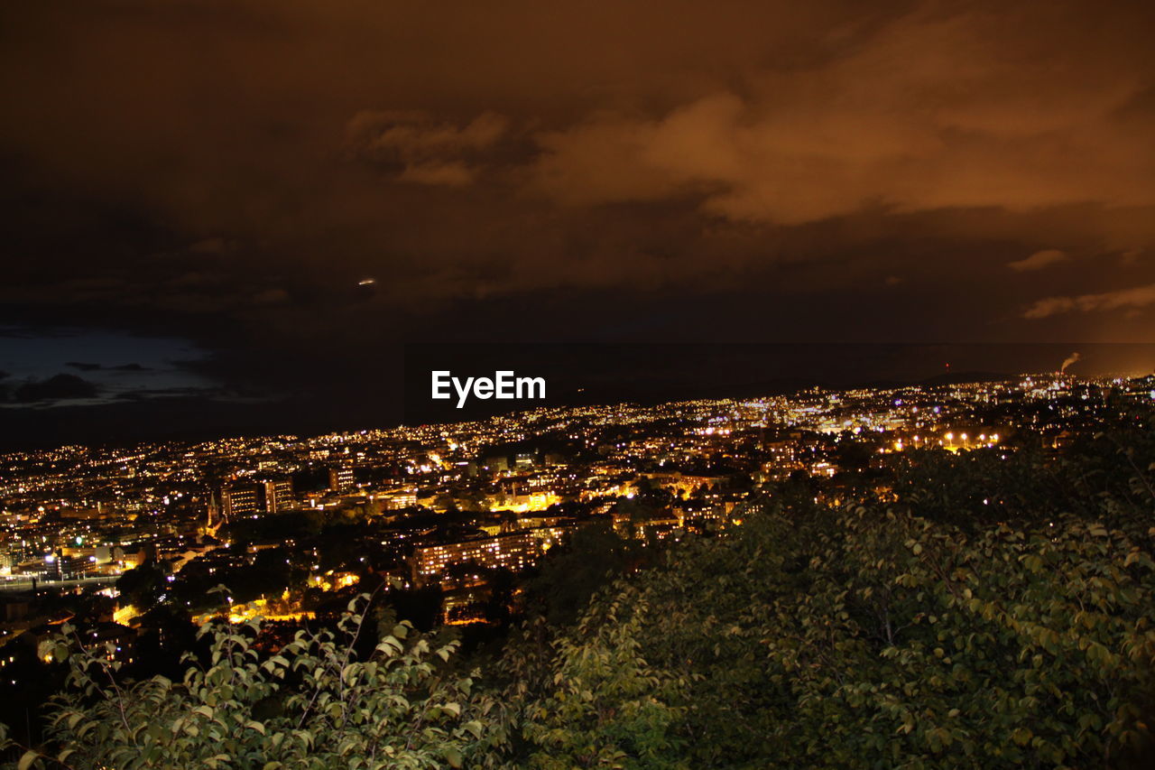 HIGH ANGLE VIEW OF ILLUMINATED BUILDINGS AT NIGHT