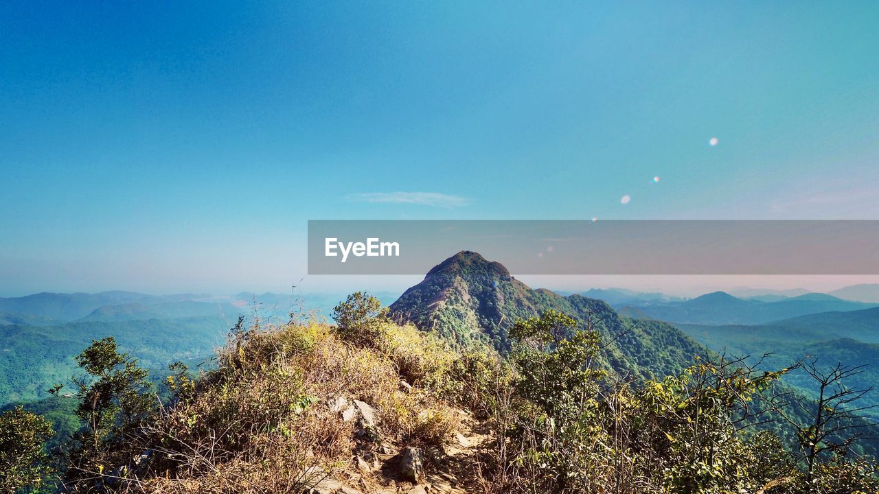 Scenic view of mountains against blue sky