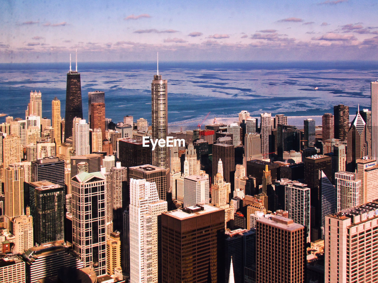 Aerial view of cityscape against cloudy sky