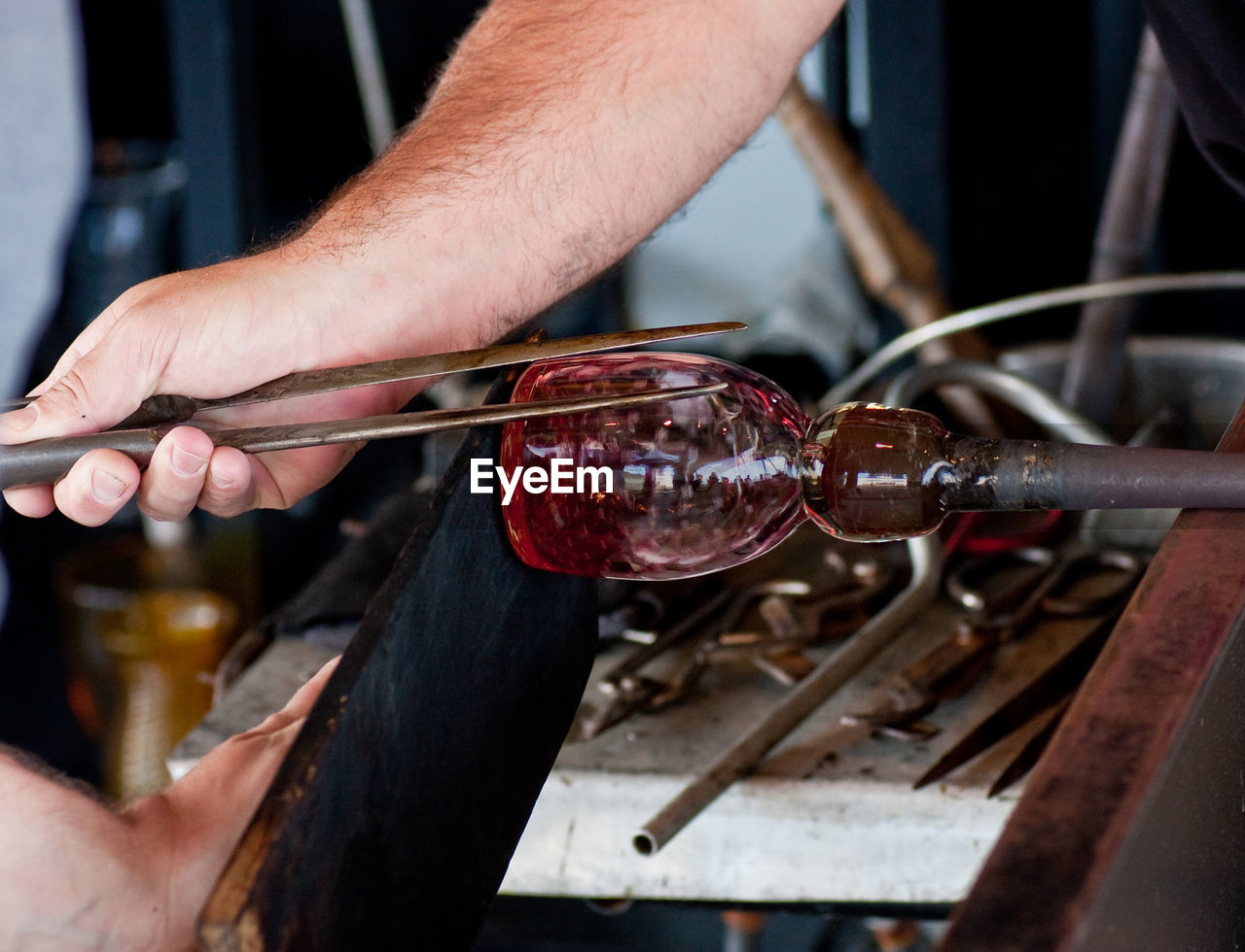 Cropped image of man making glass blower at factory