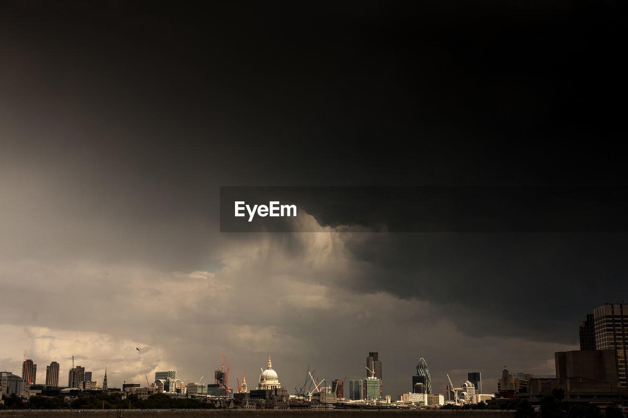 Buildings against storm clouds in city