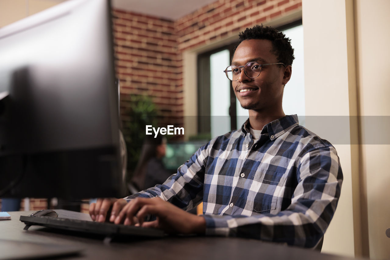 portrait of young man using laptop at table