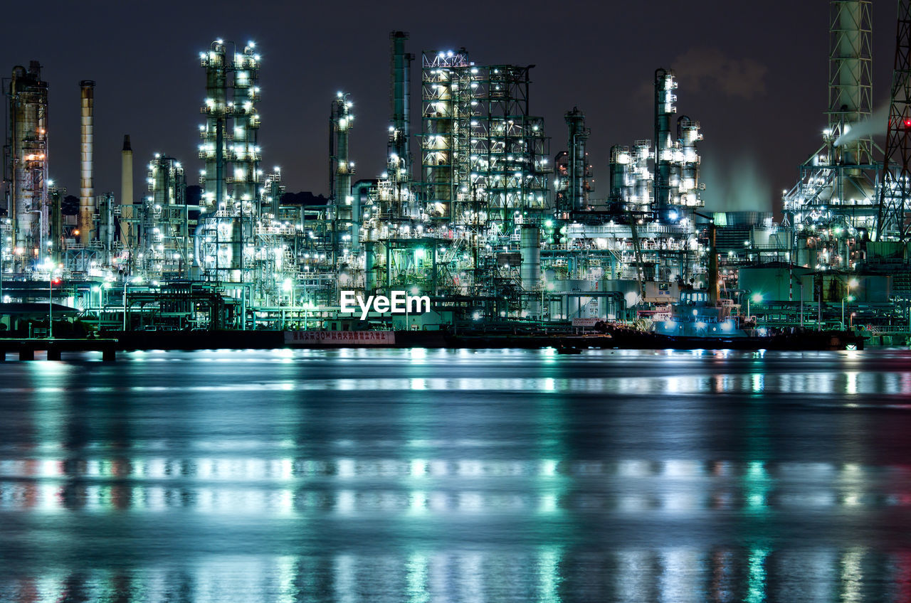 ILLUMINATED FACTORY AT NIGHT AGAINST SKY