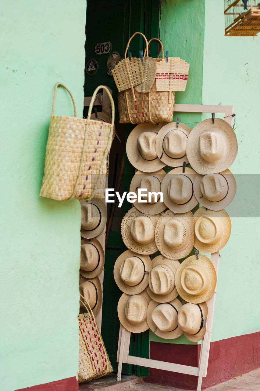 Panama style hats for sale in trinidad, cuba. straw. basket. green walls.