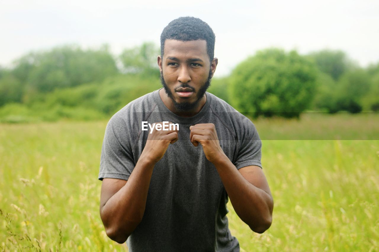 Young man in fighting stance standing on field