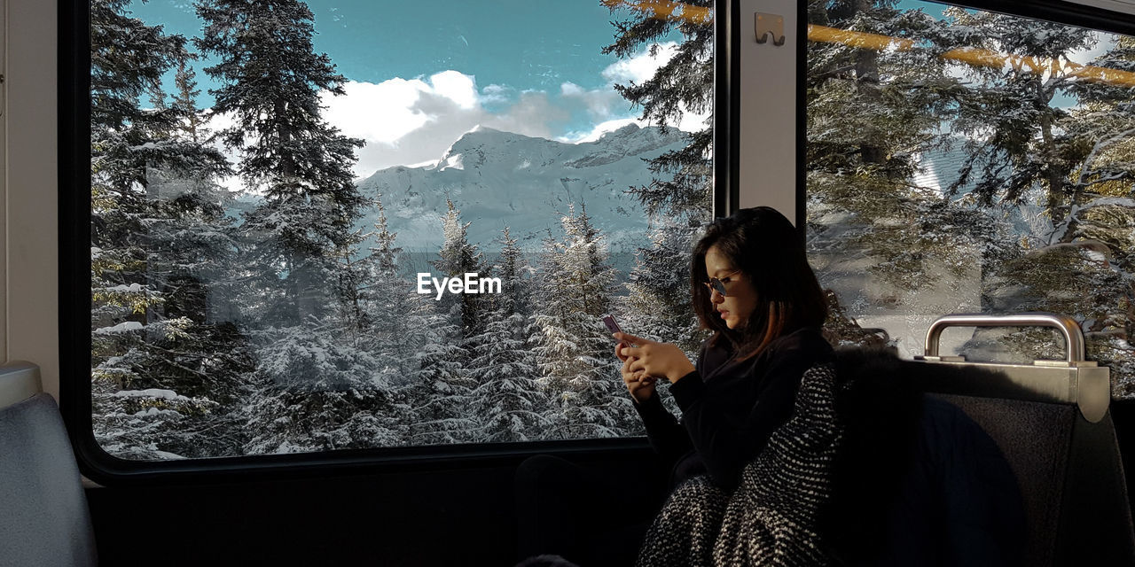 Woman looking through window in winter