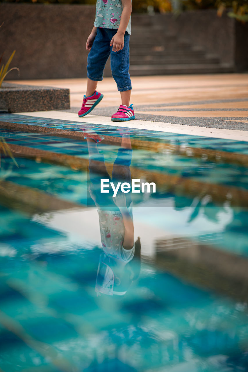 LOW SECTION OF WOMAN STANDING IN POOL