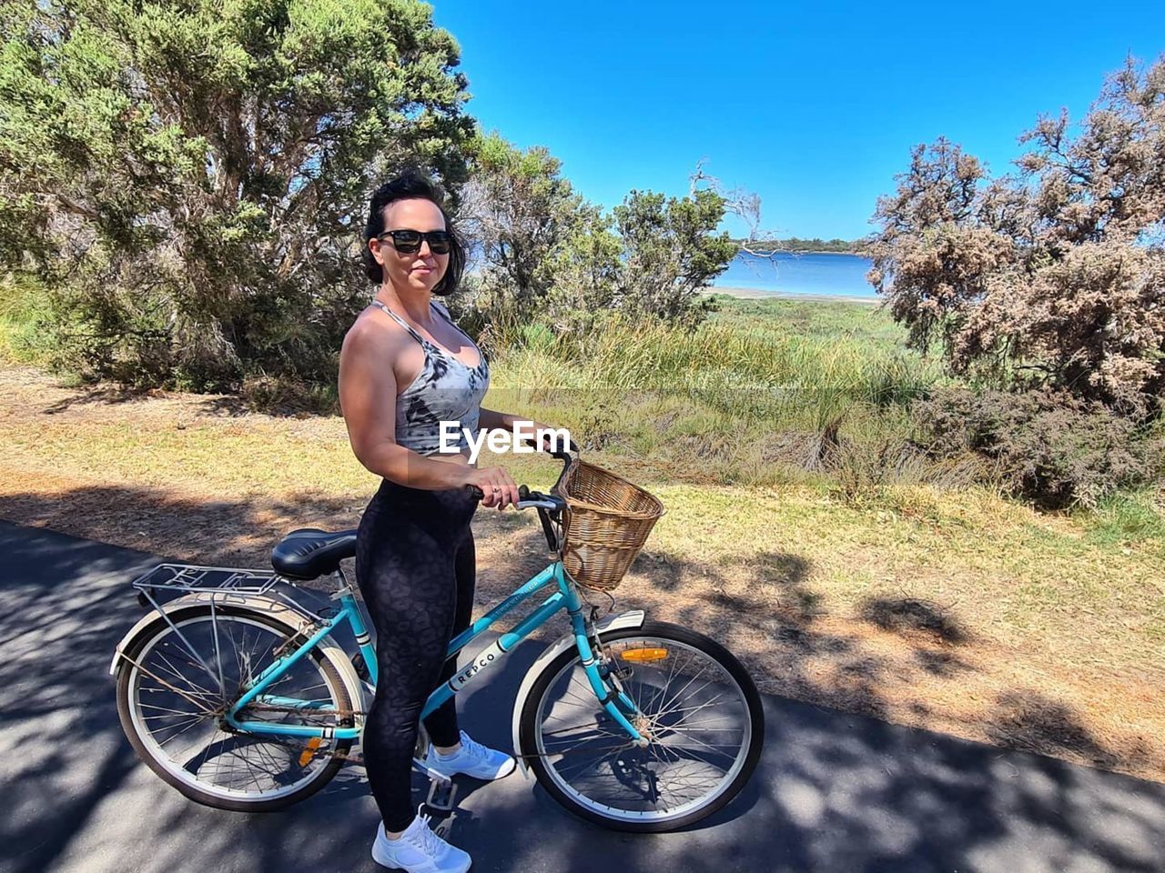 PORTRAIT OF WOMAN RIDING BICYCLE ON ROAD