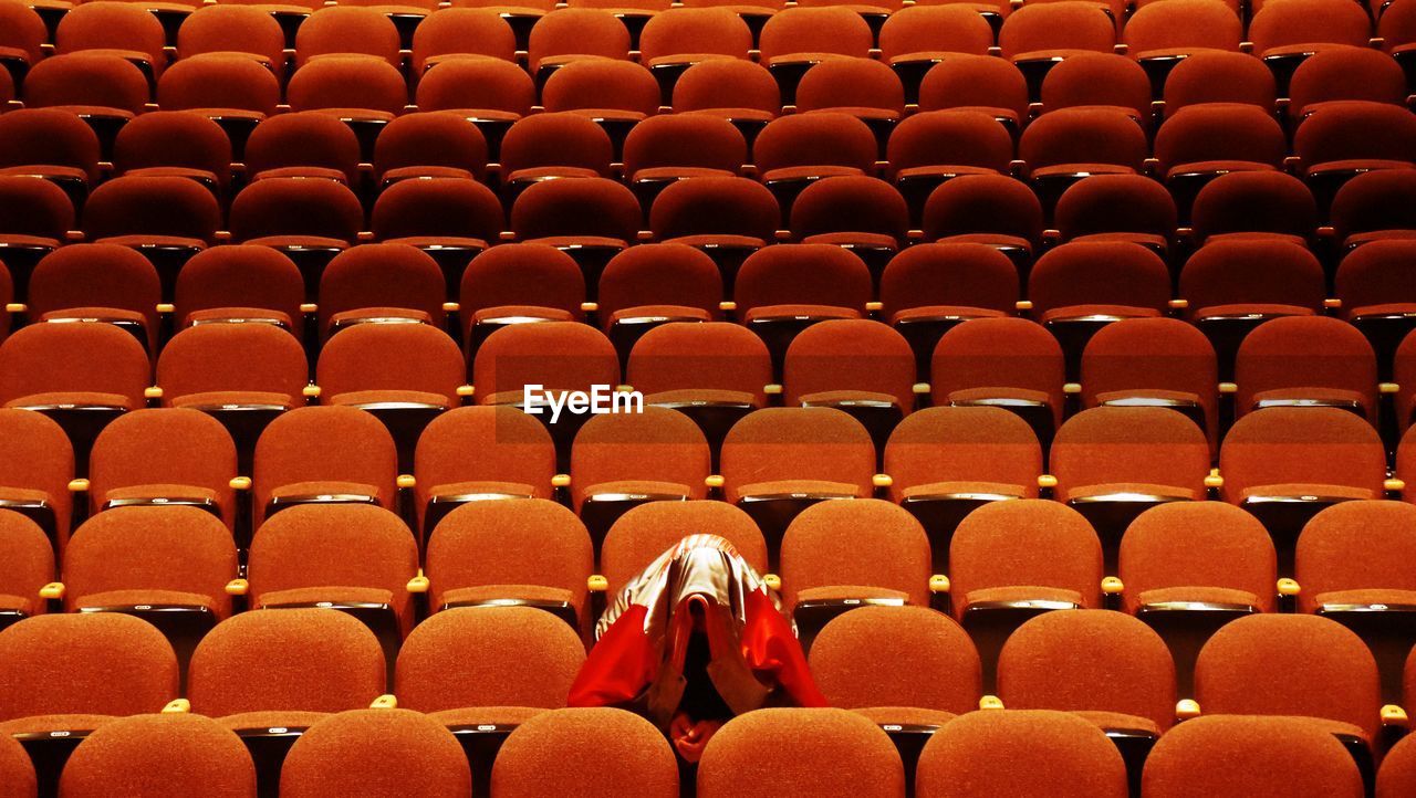 Person wearing scarf while sitting at auditorium