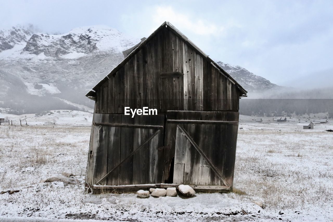 Abandoned house on field during winter