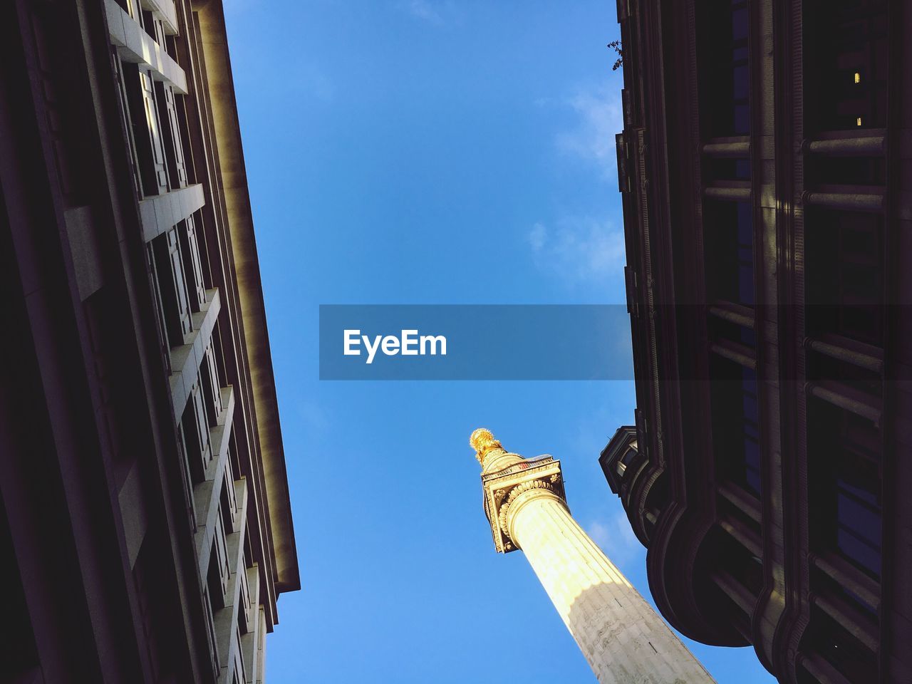 Low angle view of historic column against blue sky