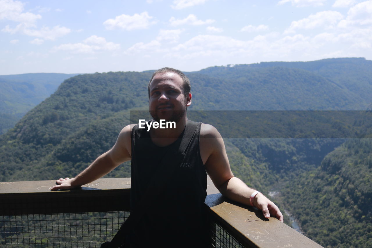 Portrait of man standing on mountain against sky