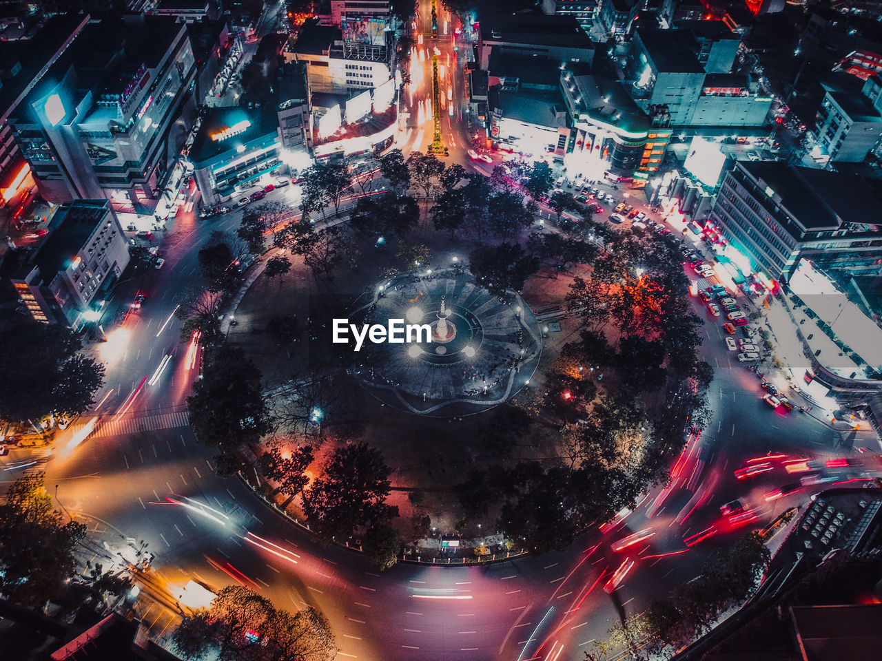 HIGH ANGLE VIEW OF ILLUMINATED STREET AMIDST BUILDINGS IN CITY