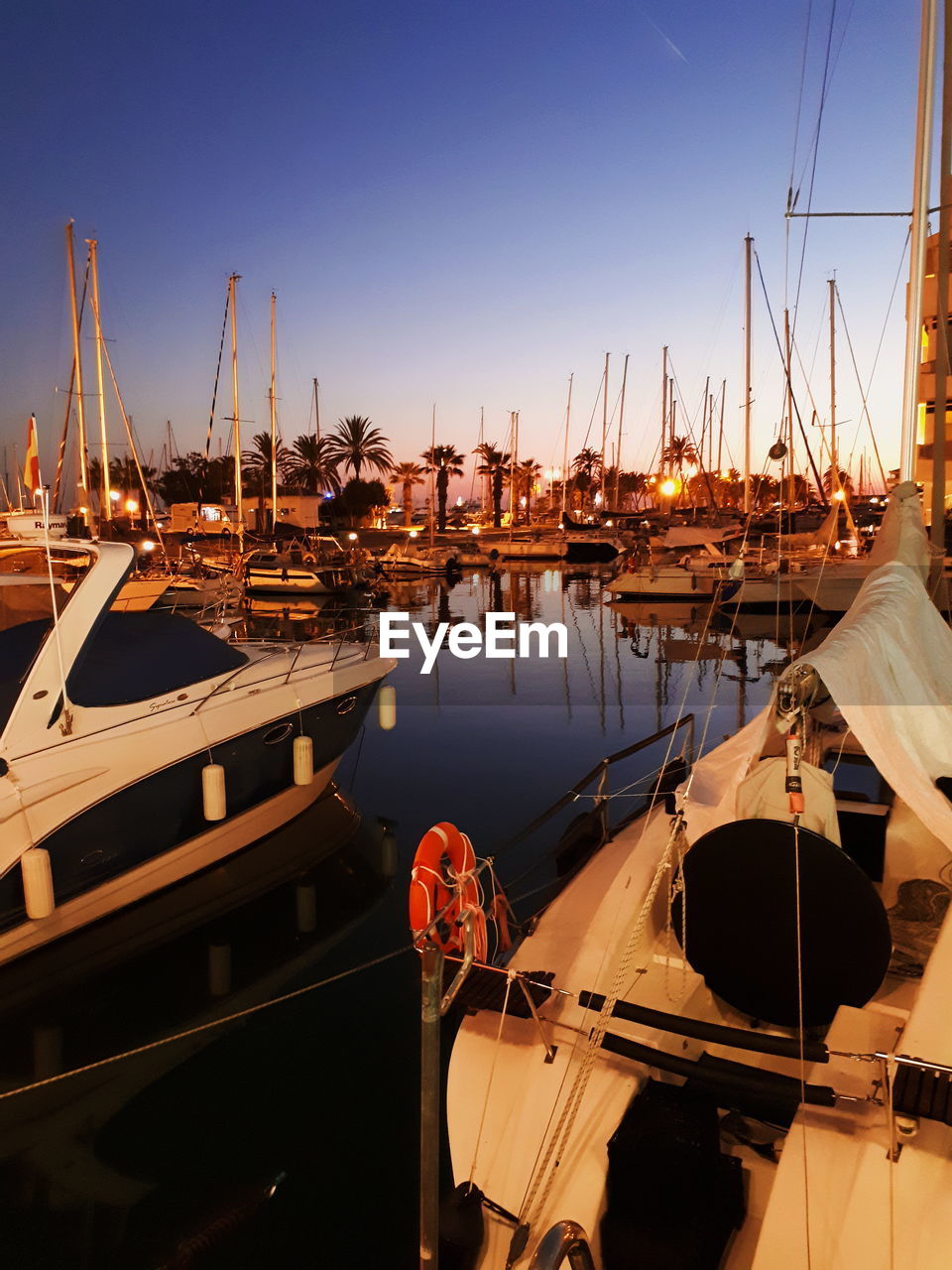 BOATS MOORED AT HARBOR AGAINST CLEAR SKY