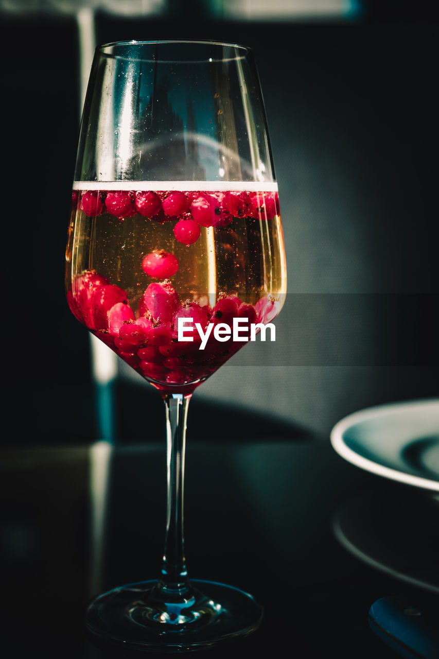 A cocktail at a party in summer with red berries in a glas on a table