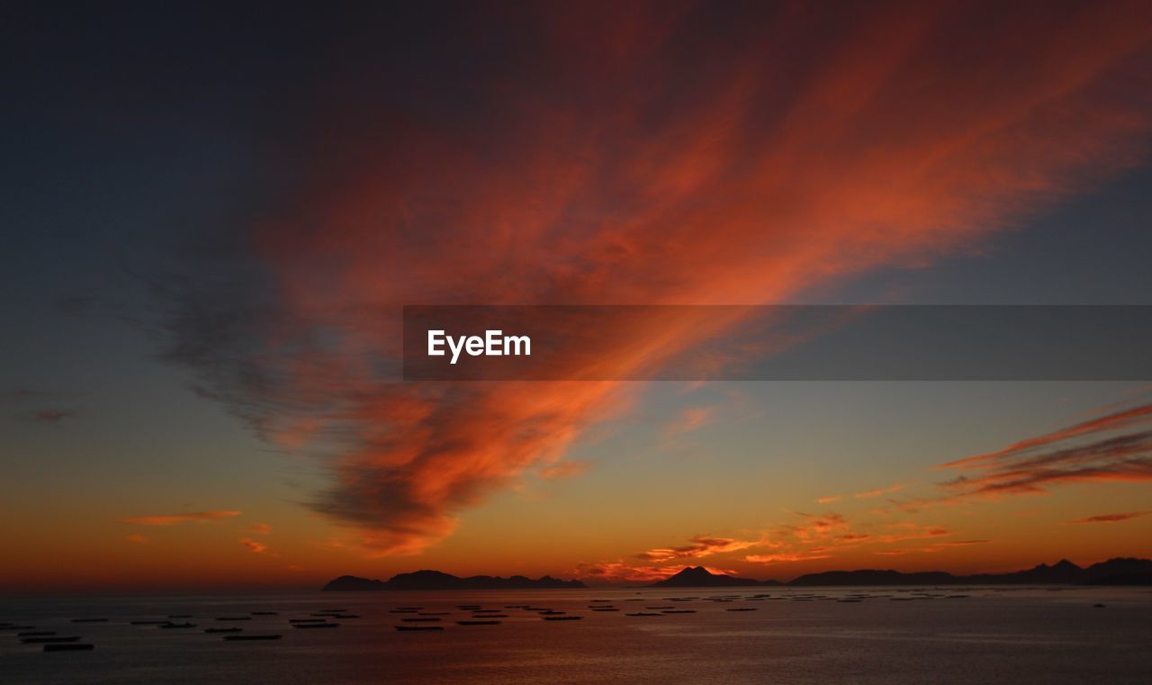 Scenic view of dramatic sky over sea during sunset