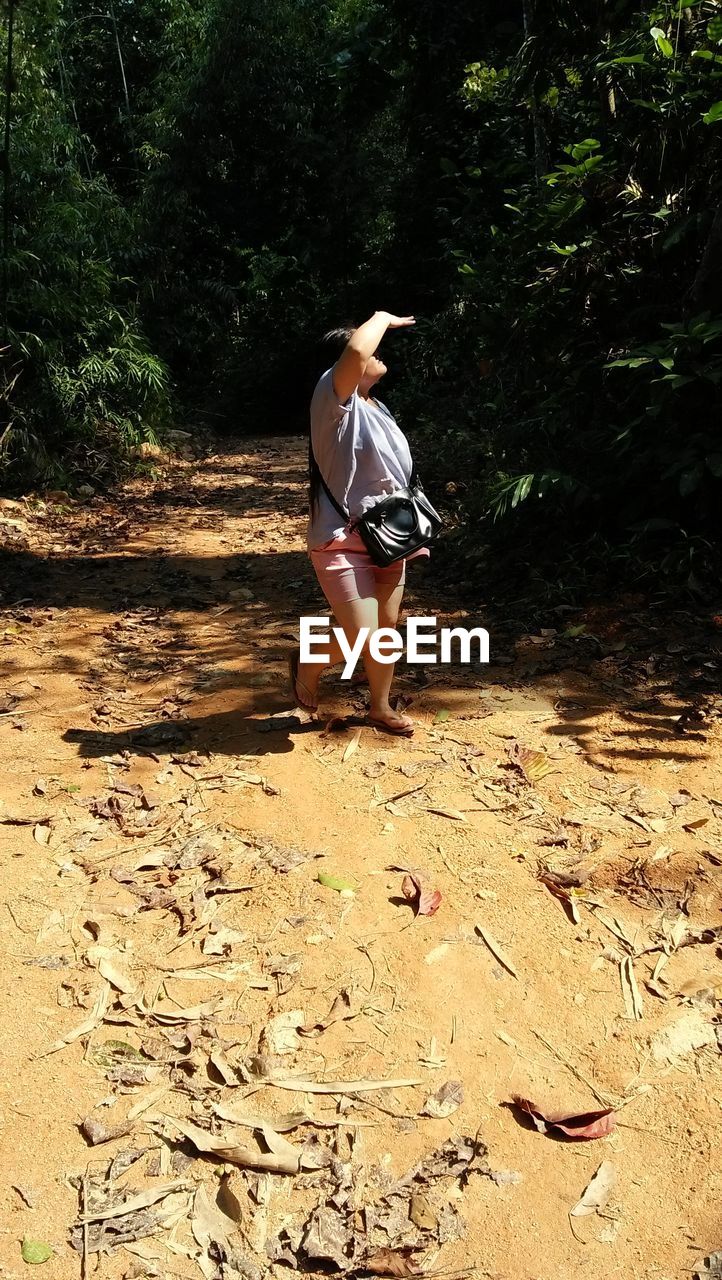 YOUNG WOMAN WALKING IN FOREST