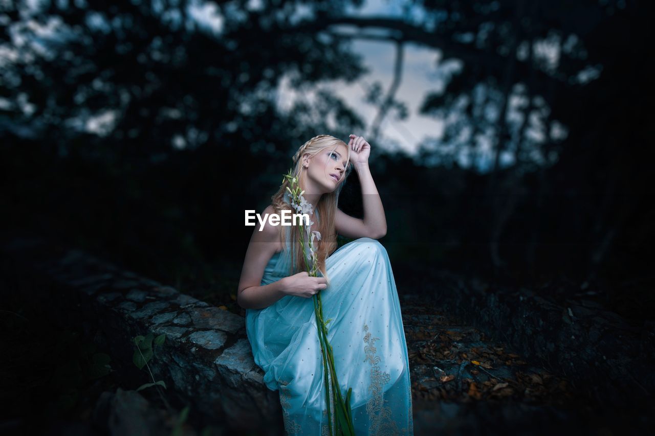 YOUNG WOMAN LOOKING AT FOREST