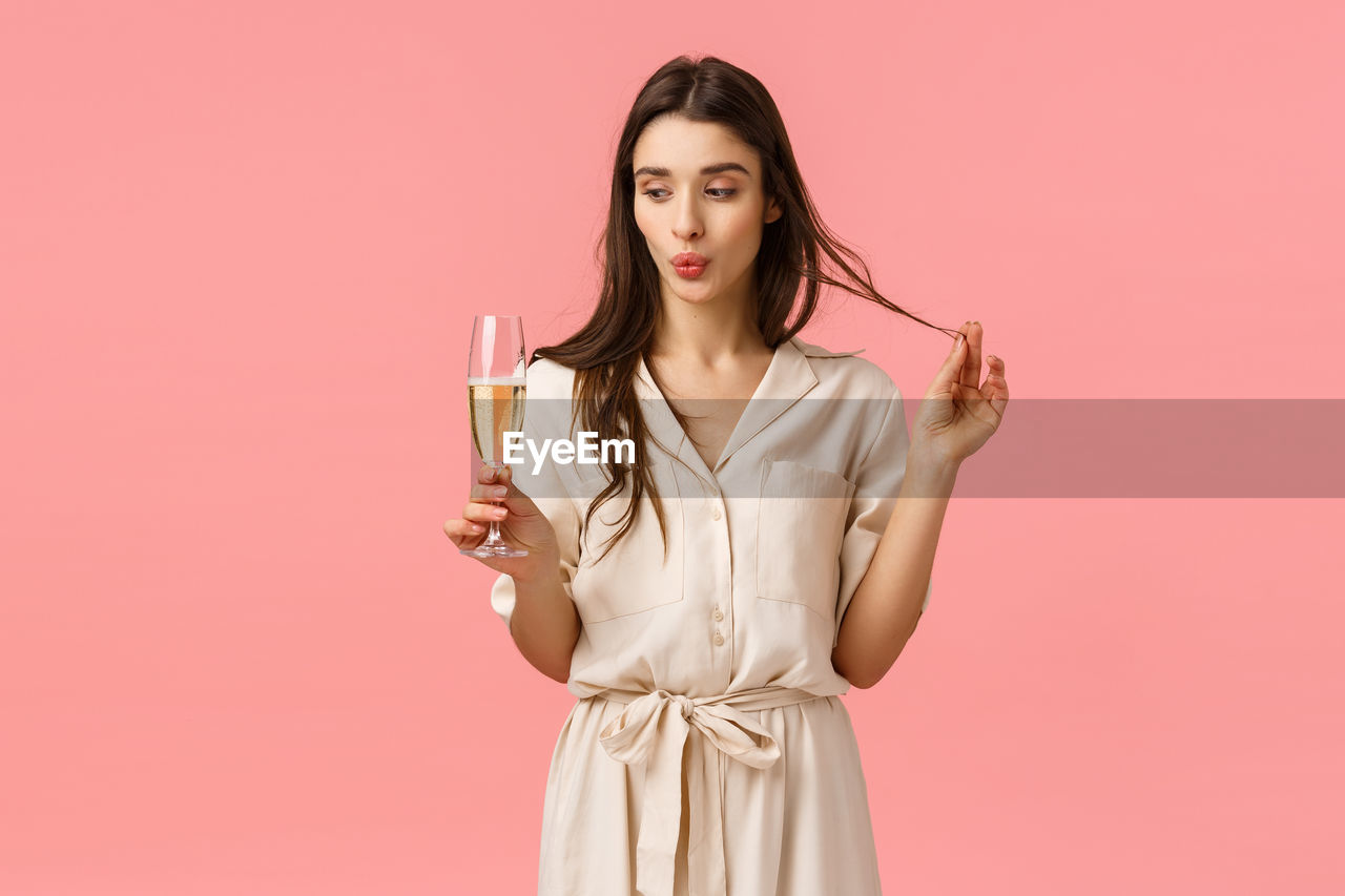 PORTRAIT OF A BEAUTIFUL YOUNG WOMAN DRINKING GLASS