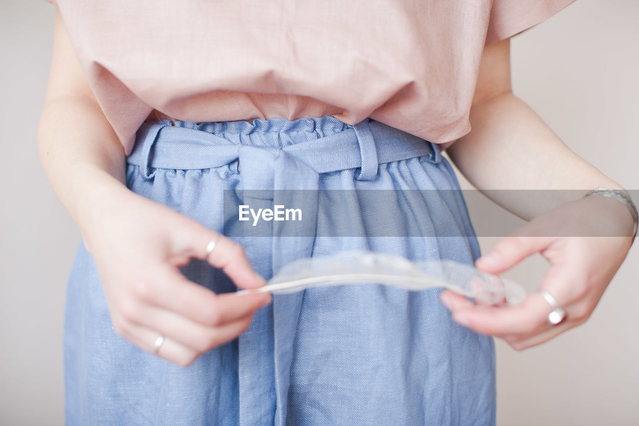 Midsection of mid adult woman holding feather