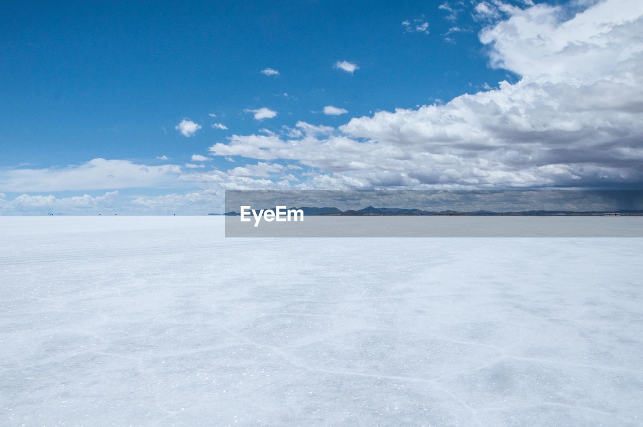 SCENIC VIEW OF FROZEN LAKE AGAINST SKY