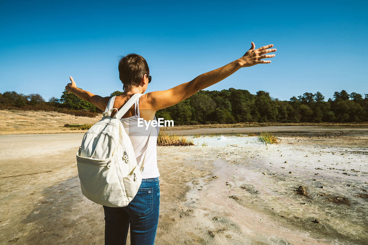 Young woman trekking to the solfatara di manziana, a sulphurous area of italy.