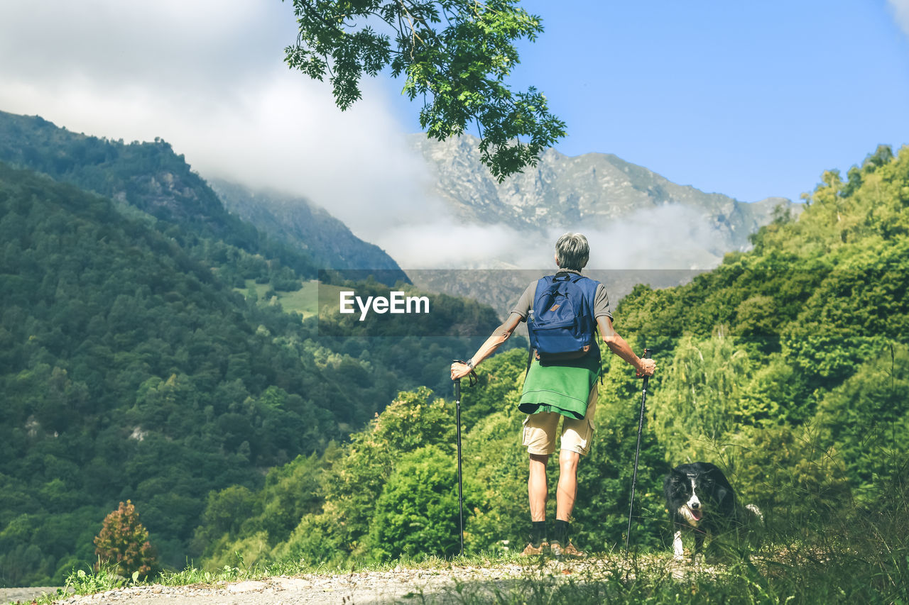 Man walking in mountain forest. male with backpack do hike in the nature. guy goes trekking outdoor