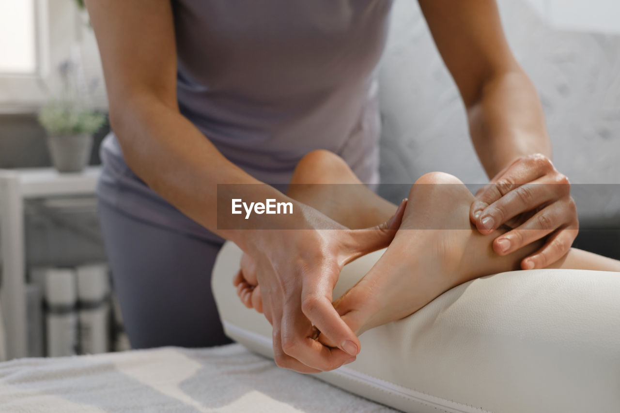 Child foot massage treatment by professional massage therapist in spa resort. wellness, stress