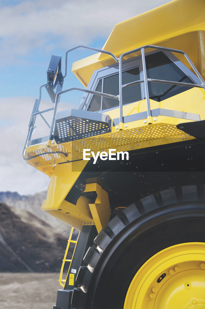 Low angle view of yellow construction machinery against sky