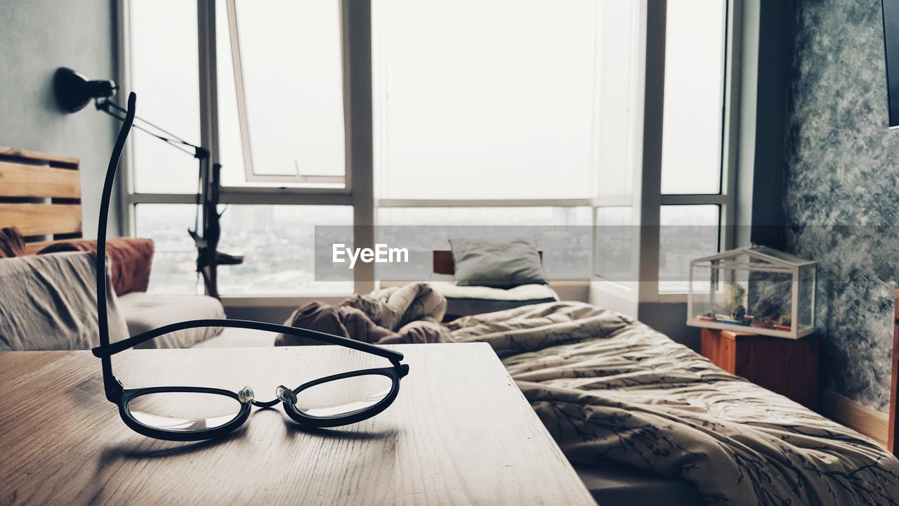 Close-up of eyeglasses on table by bed
