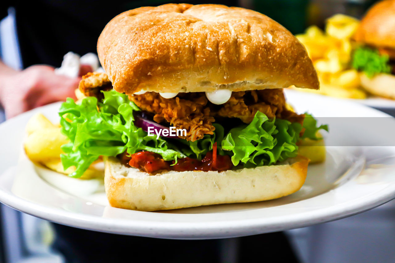 CLOSE-UP OF BURGER IN PLATE WITH BREAD