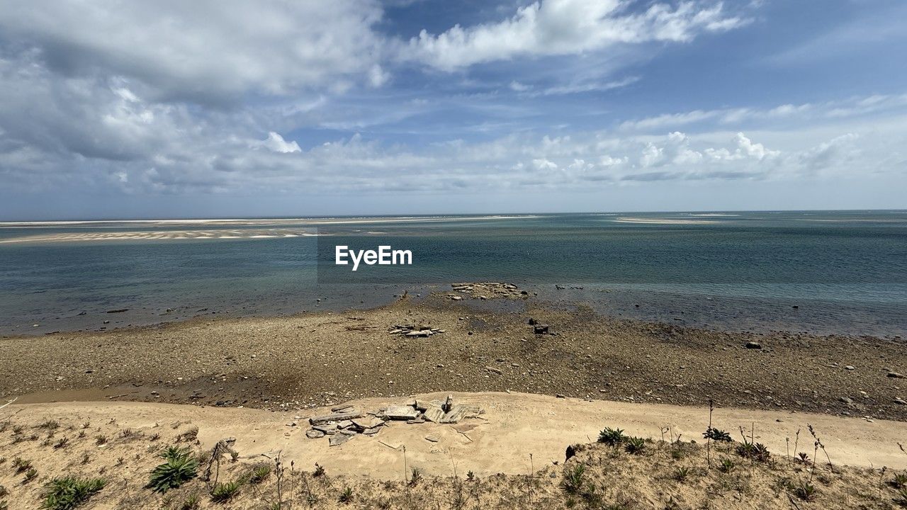 land, sea, sky, beach, water, horizon, body of water, cloud, scenics - nature, sand, beauty in nature, nature, shore, ocean, coast, environment, landscape, tranquility, wave, horizon over water, travel destinations, tranquil scene, natural environment, travel, coastline, rock, day, no people, tourism, wind wave, outdoors, non-urban scene, trip, vacation, seascape, holiday, bay, water's edge, animal, animal wildlife