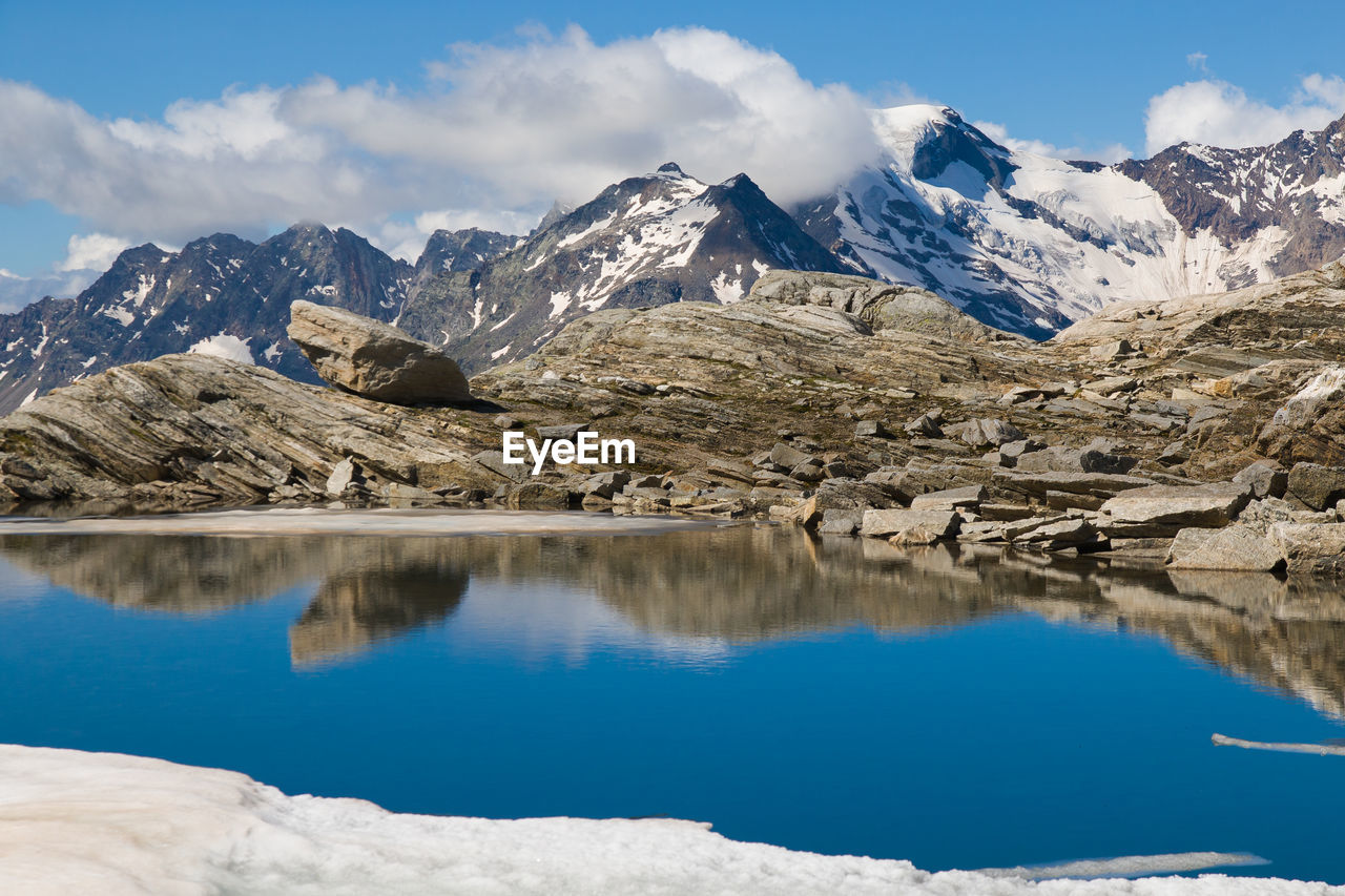 Colorful emerald lake lago smeraldo in the italian alps with monte rosa in the background