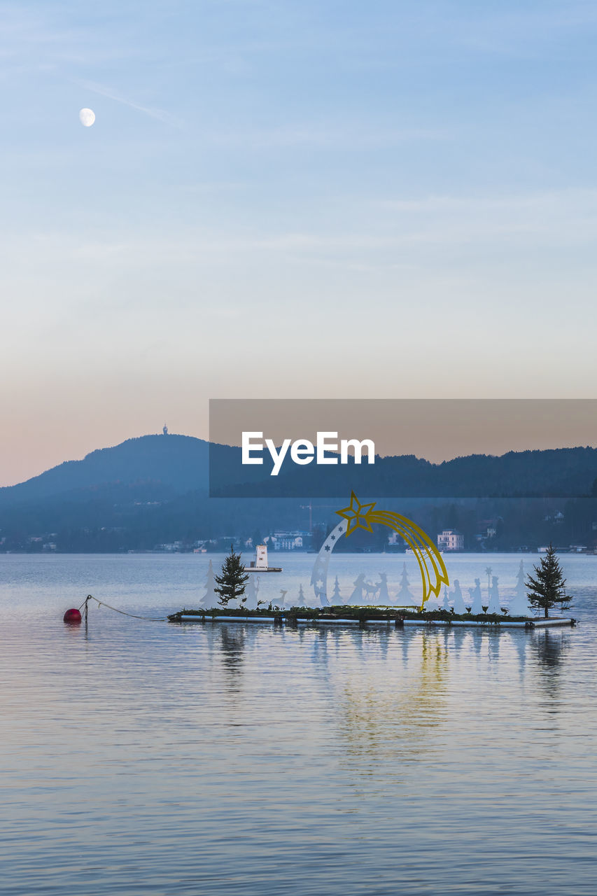 Last lights of the sunset in velden. reflections on the water and christmas atmosphere. austria.