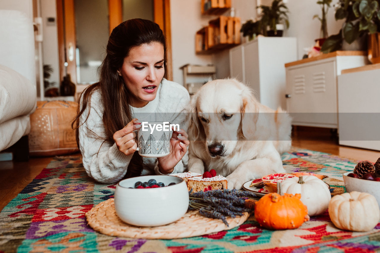 PORTRAIT OF A YOUNG MAN DRINKING DOG AT HOME