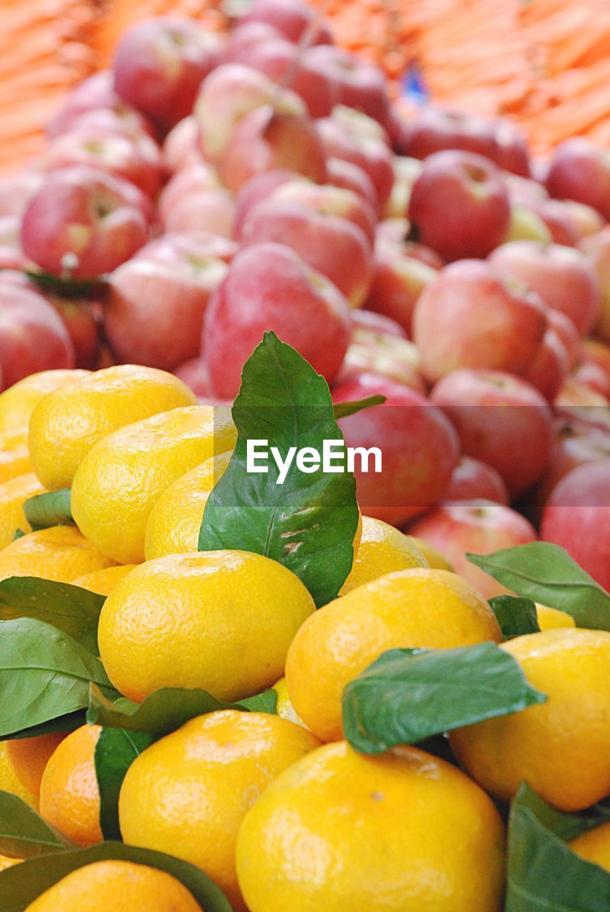 Oranges and apples for sale at market stall