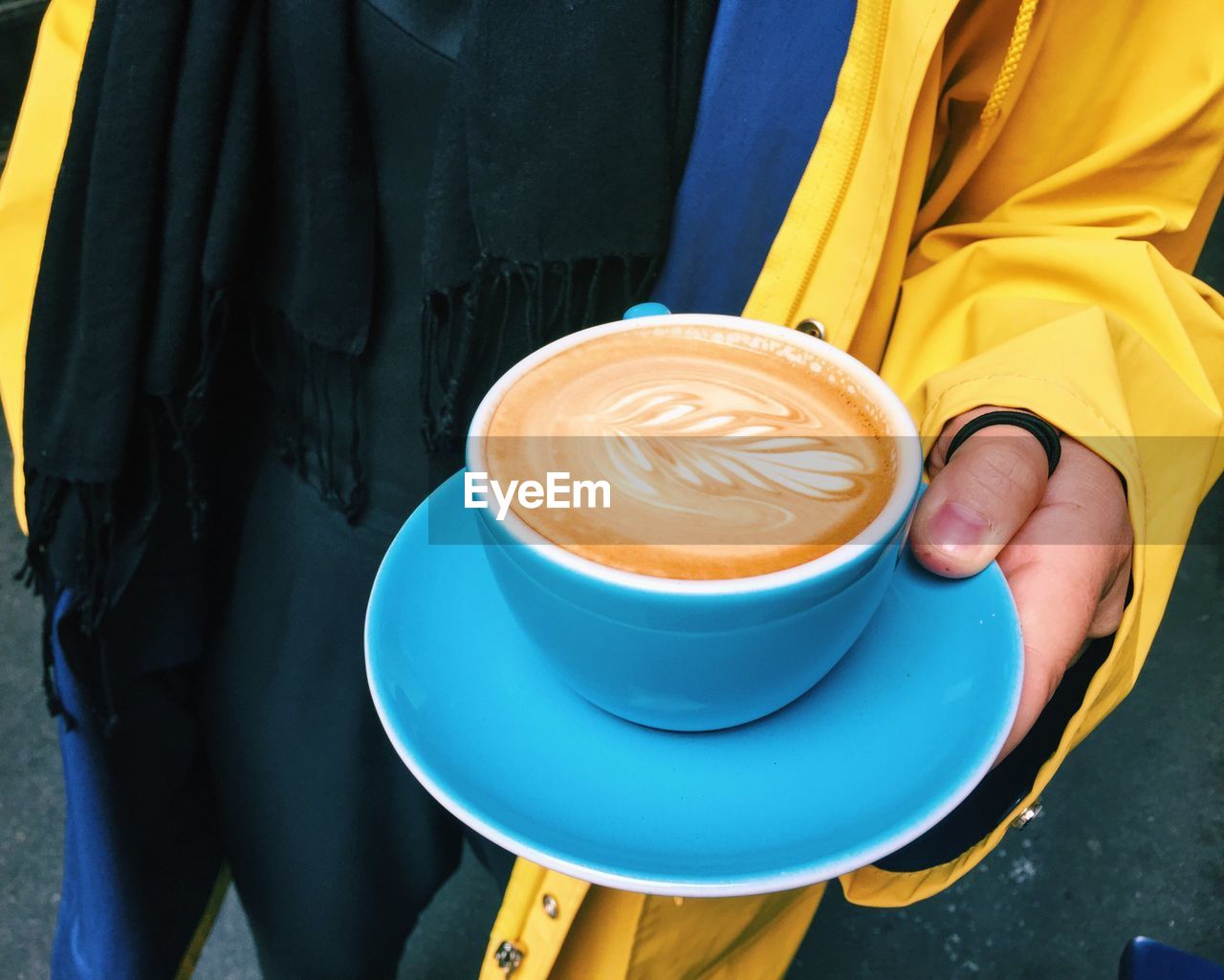 Midsection of man holding coffee cup