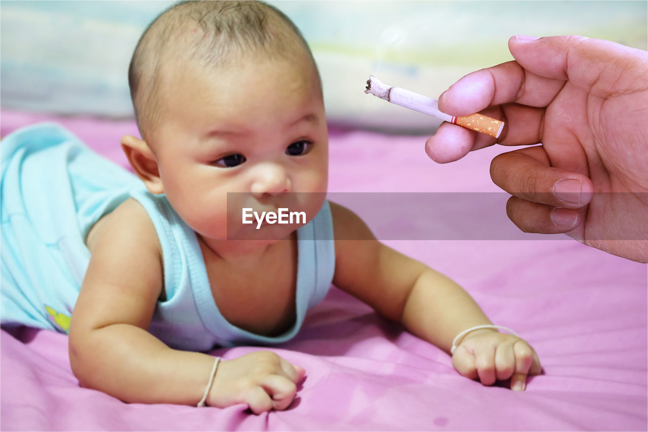 MIDSECTION OF WOMAN HOLDING BABY GIRL WITH HAND