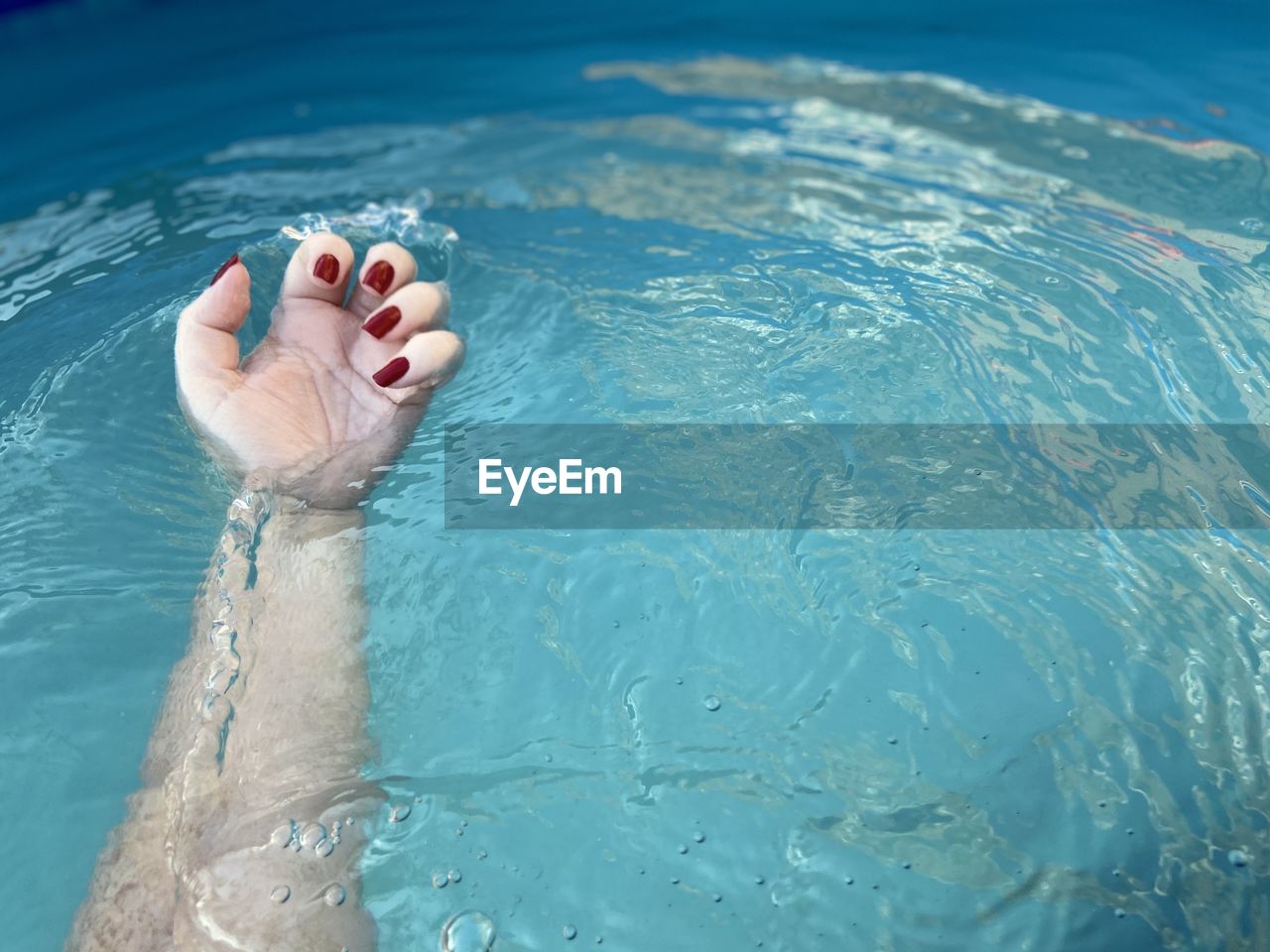 Low section of woman relaxing in swimming pool