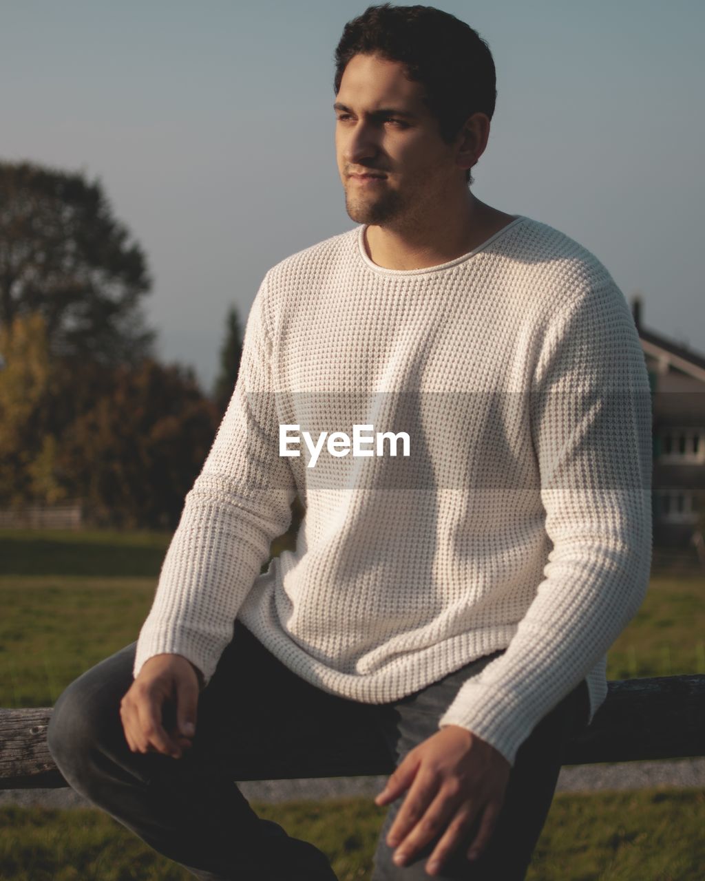 YOUNG MAN SITTING ON LAND