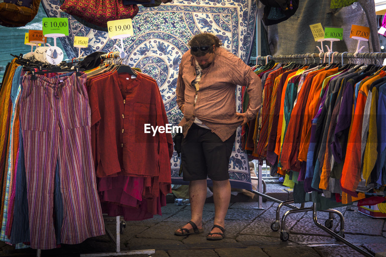 FULL LENGTH OF MAN STANDING ON DISPLAY AT STORE