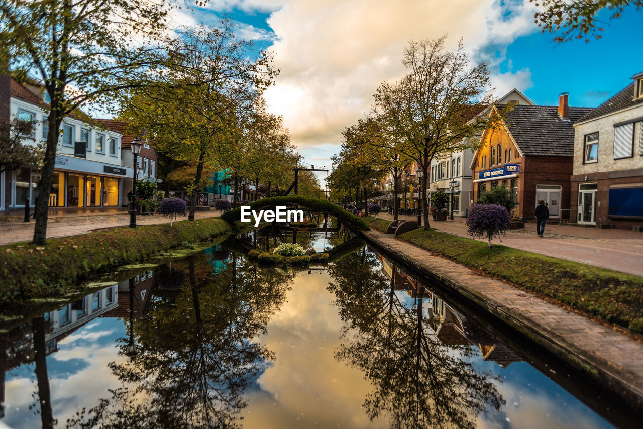 Reflection of trees and buildings in canal