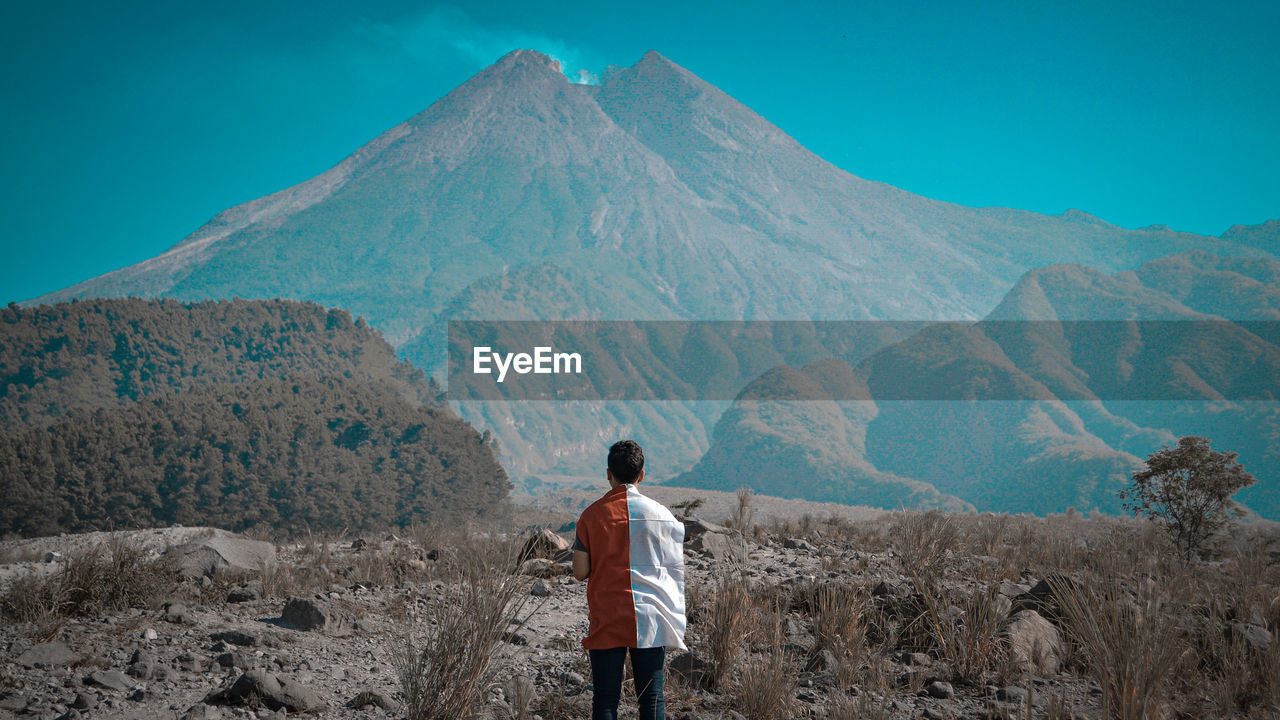 Rear view of man standing on mountain landscape