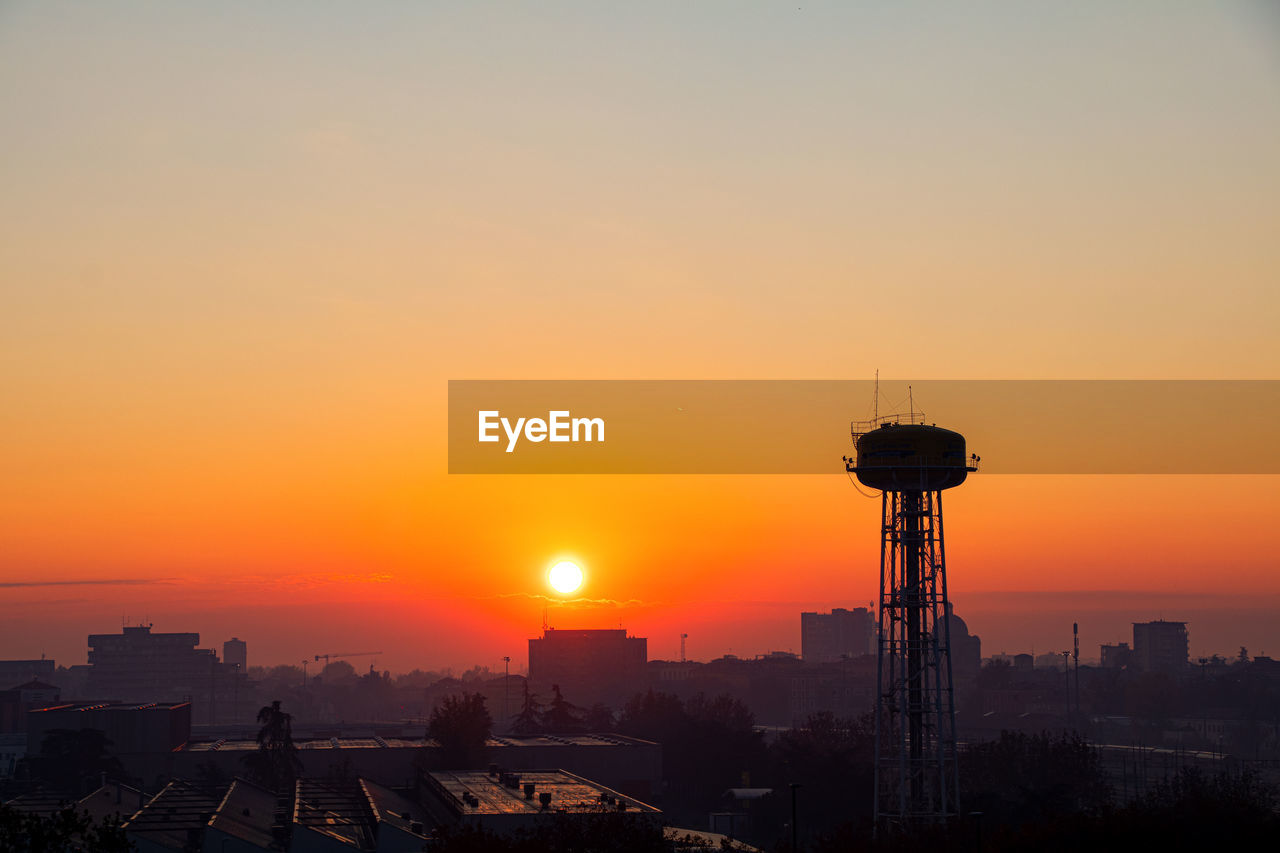 Silhouette buildings against sky during sunset