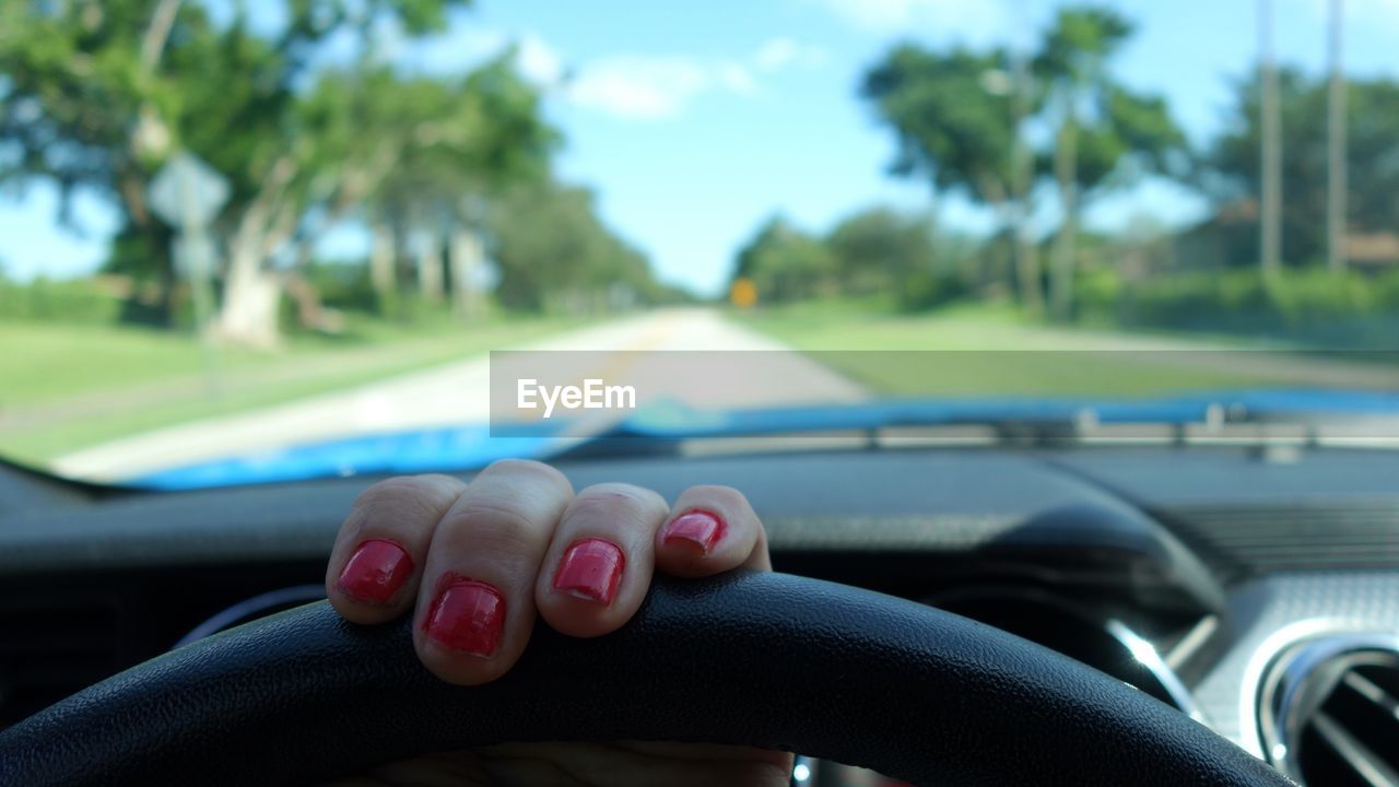 Close-up of hand driving car