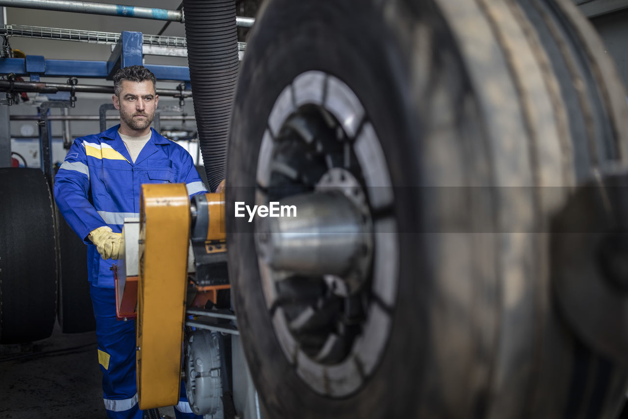 Repairman tuning tire on machine